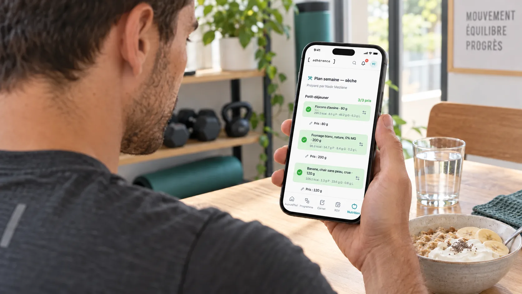 Élève consultant son plan de repas Adhérence sur un téléphone posé près d’un repas simple.