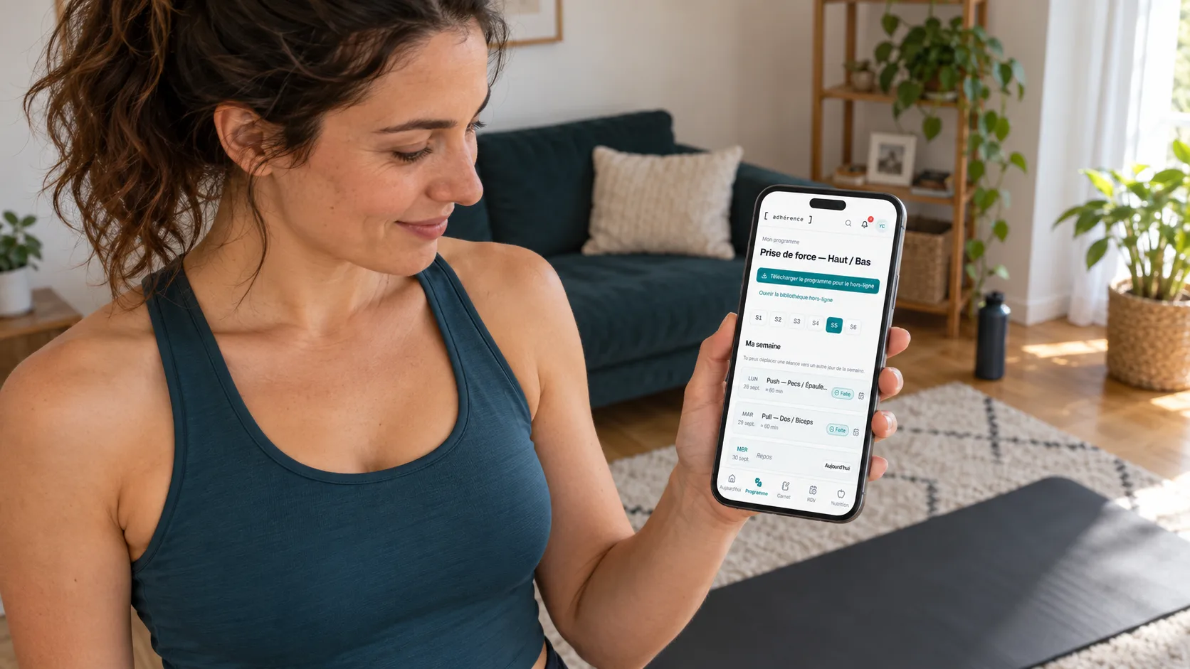 Client finding her Adhérence programme on a phone before a home workout in her living room.