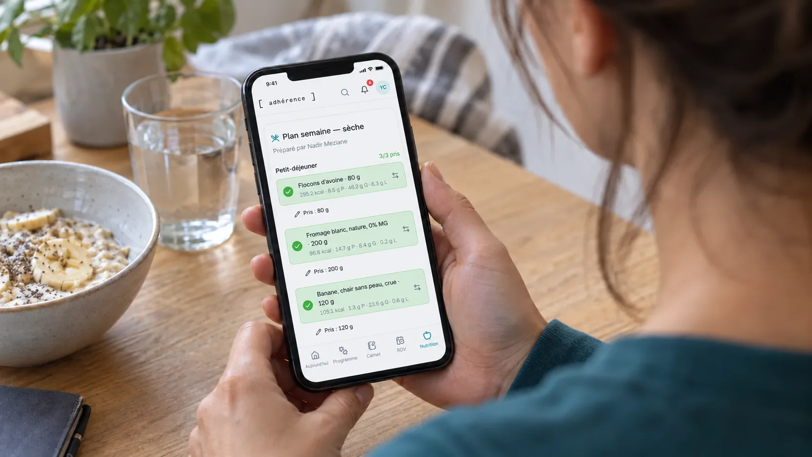 Élève consultant sa checklist alimentaire Adhérence sur un téléphone près de son petit-déjeuner.