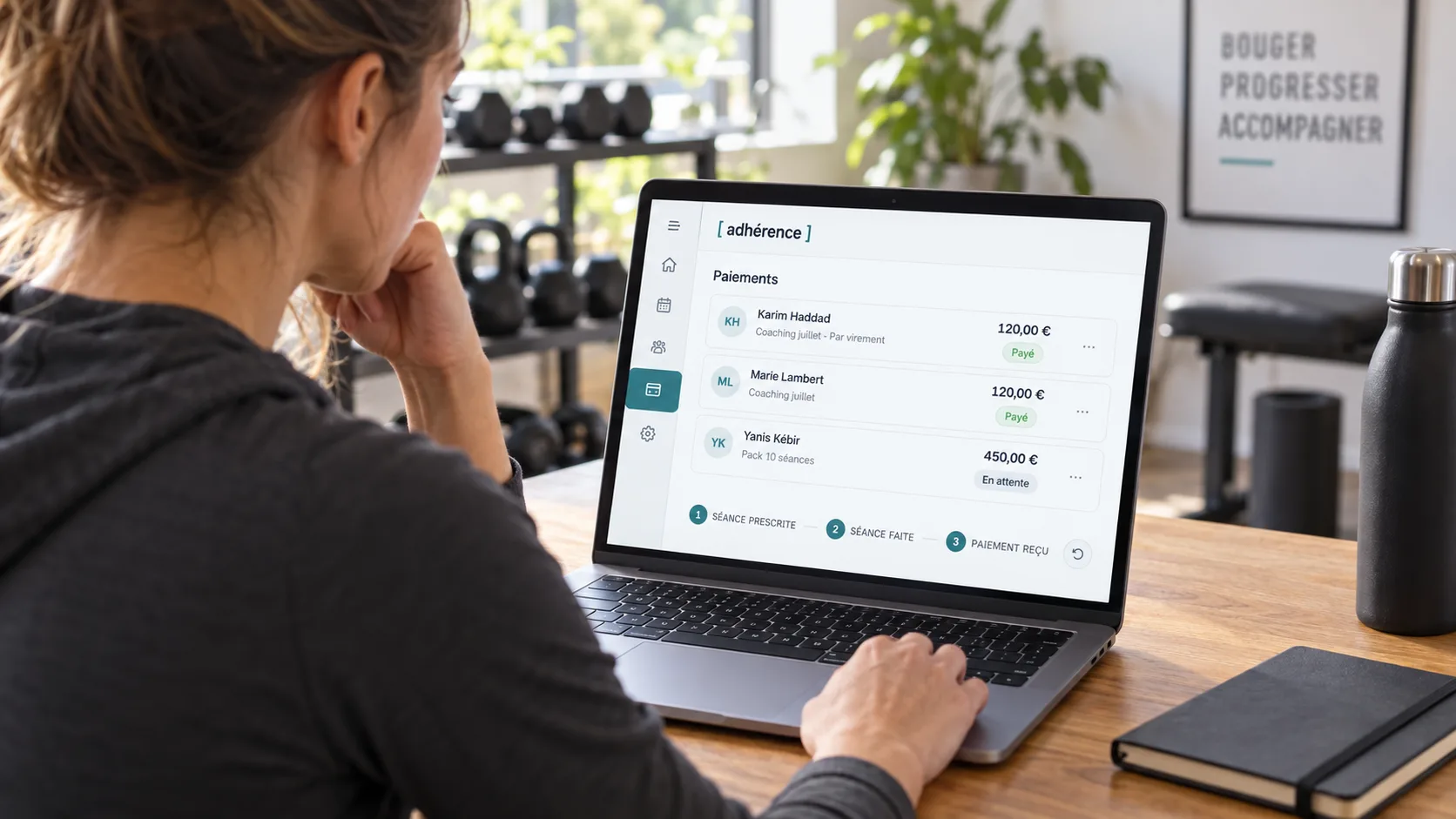 Coach sportive consultant la liste des paiements Adhérence sur un ordinateur dans son studio.