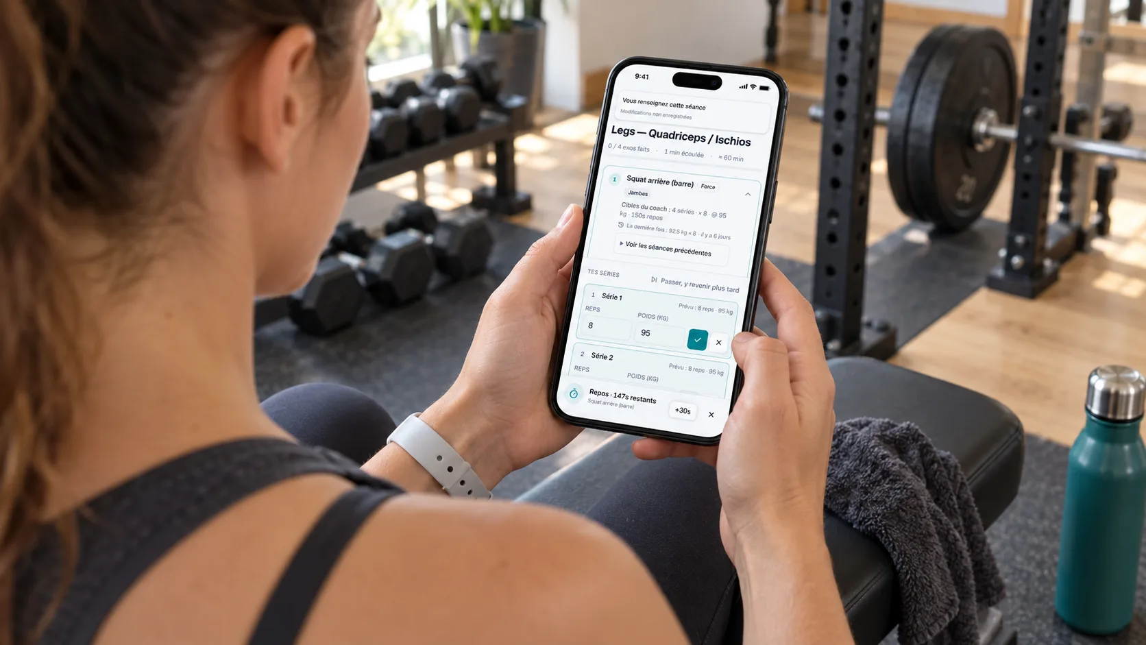 Adult gym client entering completed strength training sets in Adhérence on her phone.